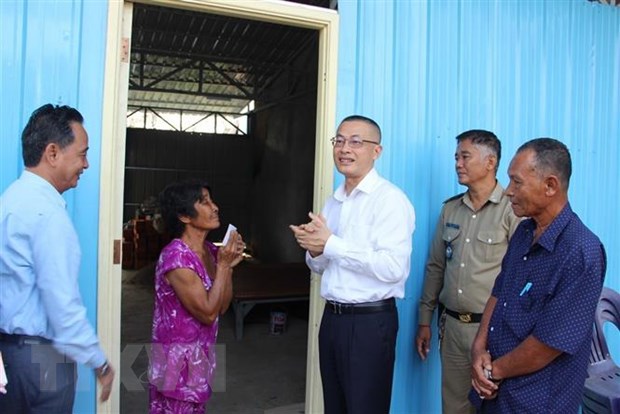 Đại sứ Việt Nam tại Campuchia Vũ Quang Minh b&agrave;n giao nh&agrave; cho b&agrave; con gốc Việt. (Ảnh: Nguyễn Vũ H&ugrave;ng/TTXVN)