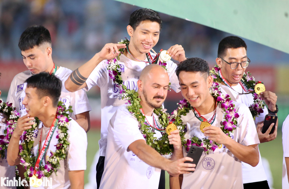 Cầu thủ của H&agrave; Nội FC chia sẻ niềm vui với người th&acirc;n qua điện thoại ngay sau khi nhận huy chương.