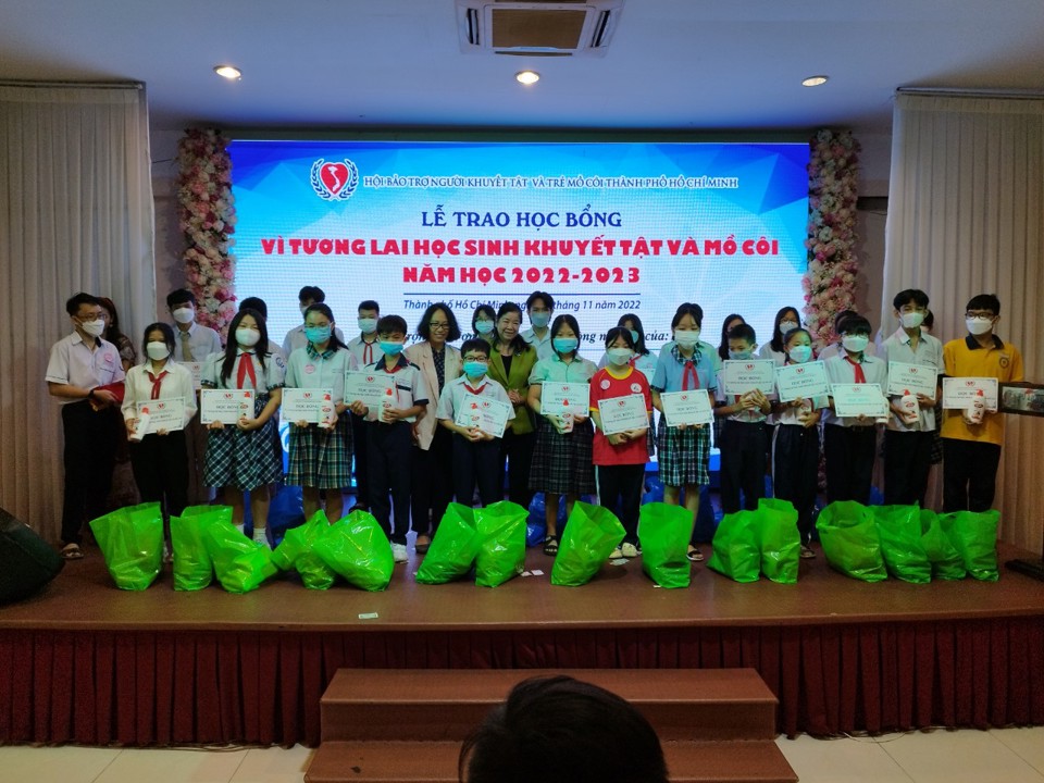 Bà Nguyễn Thị Bích Ngọc (áo xanh) và bà Nguyễn Thị Thu Nguyên - đại diện Tổ chức La Bonne Etoile trao học bổng cho học sinh.  