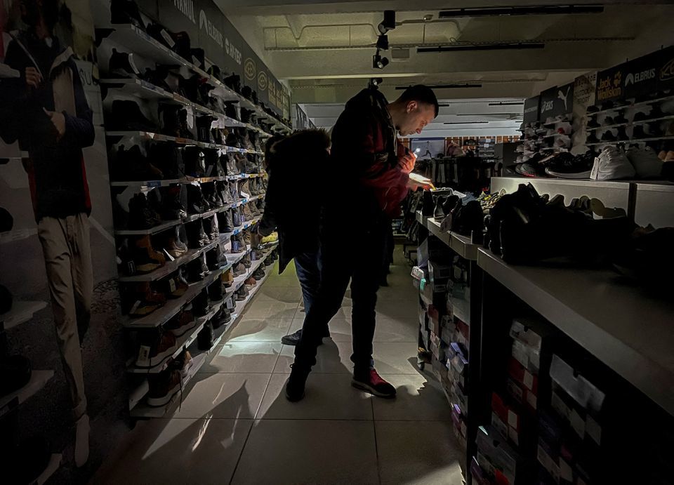 Một người dần &ocirc;ng mua sắm ở trung t&acirc;m thương mại bị mất điện tại thủ đ&ocirc; Kiev, h&ocirc;m 26/11. Ảnh: Reuters