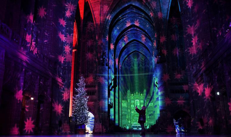 Người d&acirc;n chụp ảnh với c&acirc;y th&ocirc;ng Noel tại một nh&agrave; thờ ở Liverpool, Anh. Ảnh : Reuters