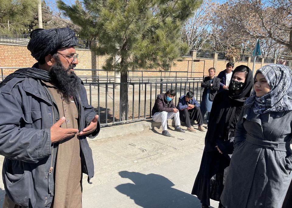 Một th&agrave;nh vi&ecirc;n của Taliban n&oacute;i chuyện với c&aacute;c nữ sinh vi&ecirc;n b&ecirc;n ngo&agrave;i Đại học Gi&aacute;o dục Kabul ở Kabul, Afghanistan, ng&agrave;y 26/2/2022. Ảnh: Reuters