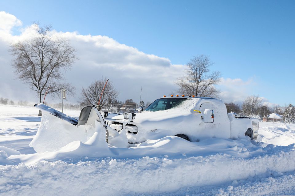 Một chiếc xe ủi tuyết bị mắc kẹt tr&ecirc;n đường Main St. ở Amherst, New York h&ocirc;m 25/12. Ảnh: Reuters