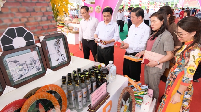 Đại diện Sở NN&amp;PTNT H&agrave; Nội tham quan gian trưng b&agrave;y, giới thiệu sản phẩm OCOP tại huyện Thạch Thất. Ảnh: L&acirc;m Nguyễn.