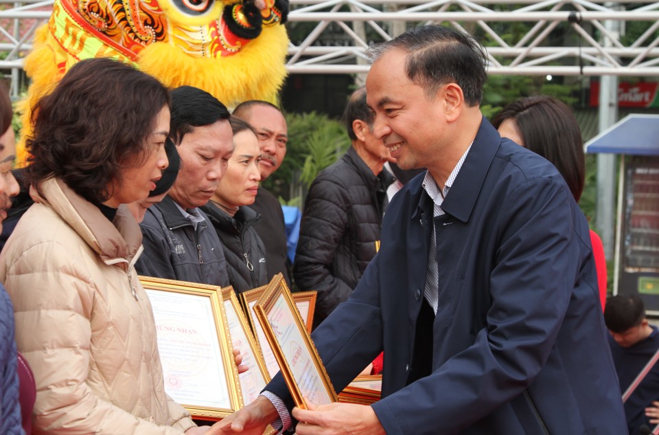 Chủ tịch UBND quận T&acirc;y Hồ Nguyễn Đ&igrave;nh Khuyến trao chứng nhận tham dự hội thi "Tay nghề l&agrave;ng đ&agrave;o thống Nhật T&acirc;n" cho đại diện c&aacute;c nh&agrave; vườn.