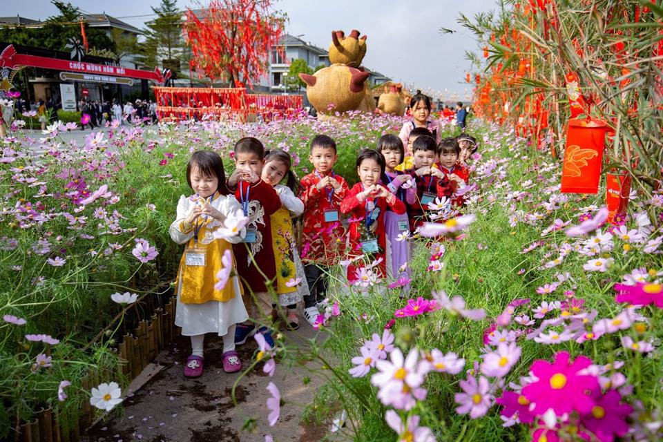 Các “du khách nhí” diện áo dài du Xuân giữa đường hoa Home Hanoi Xuan 2023. Ảnh: Đinh Tùng