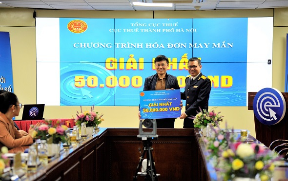 Đại diện Cục Thuế TP Hà Nội trao giải cho ông Lương Hải Việt là cá nhân may mắn trúng giải Nhất chương trình quay số hóa đơn may mắn quý III/2022.