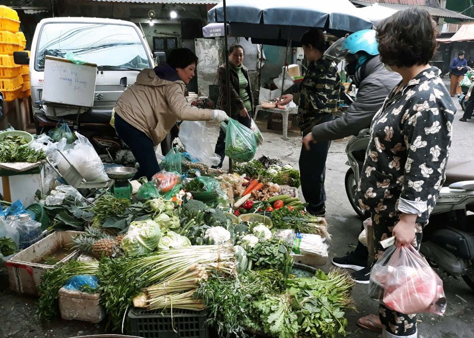 Người ti&ecirc;u d&ugrave;ng mua rau xanh tại chợ truyền thống. Ảnh: Ho&agrave;i Nam