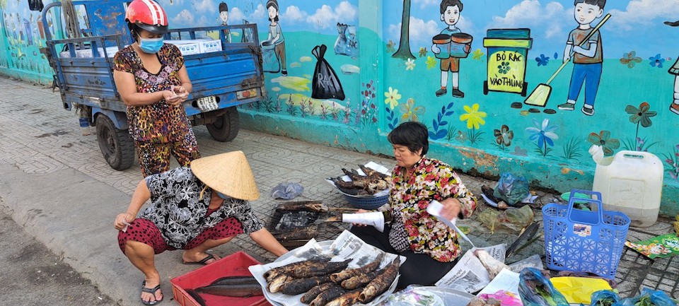 Một người dân dừng lại mua cá lóc nướng trên đường Bình Tây, quận 6, TP Hồ Chí Minh. Ảnh: Tân Tiến