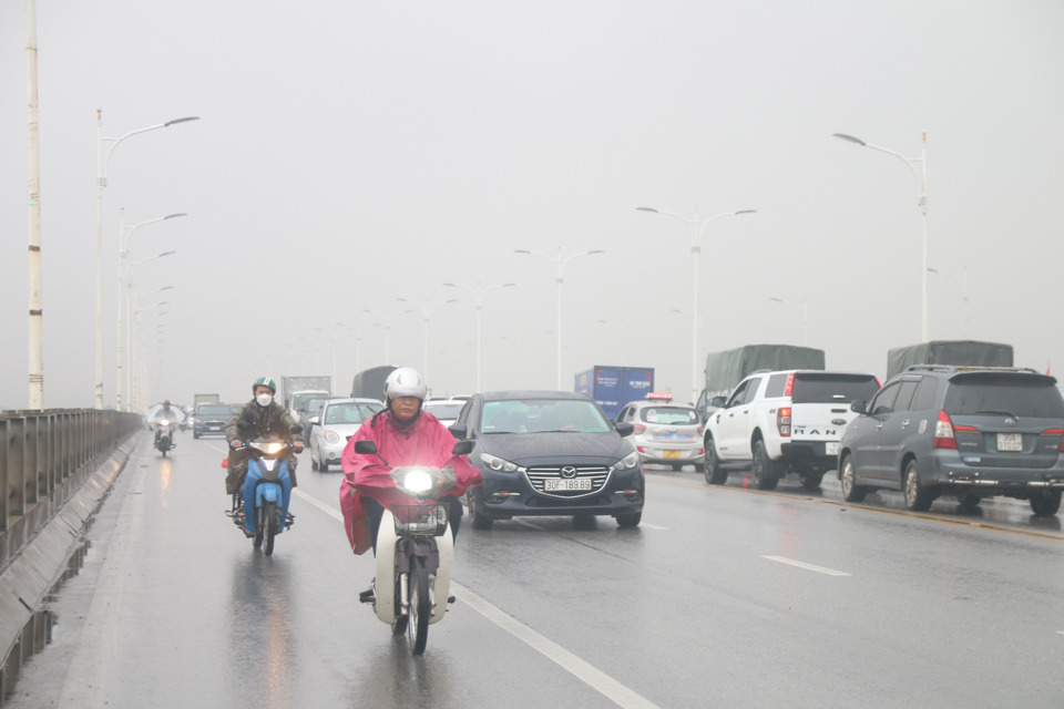 Lớp sương m&ugrave; d&agrave;y đặc bao phủ tại c&aacute;c đường tr&ecirc;n H&agrave; Nội từ s&aacute;ng, người d&acirc;n phải bật đ&egrave;n khi di chuyển