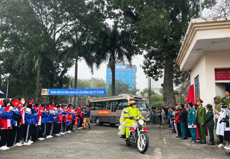 Xe chở t&acirc;n binh l&ecirc;n đường trước sự vẫy ch&agrave;o của học sinh, sinh vi&ecirc;n, người th&acirc;n.