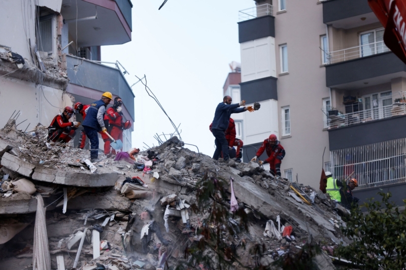 Người d&acirc;n v&agrave; nh&acirc;n vi&ecirc;n cứu hộ đứng tr&ecirc;n đống đổ n&aacute;t của một t&ograve;a nh&agrave; bị sập sau trận động đất ở Adana, Thổ Nhĩ Kỳ ng&agrave;y 7/2/2023. Ảnh: Reuters