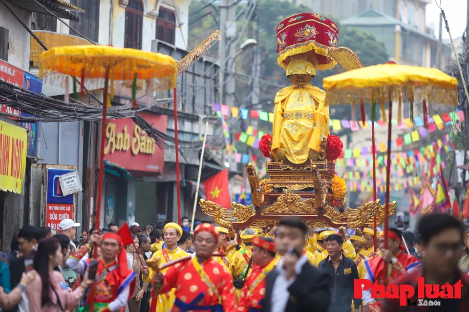 Đo&agrave;n rước kiệu th&aacute;nh V&acirc;n Du đi qua đường l&agrave;ng, 2 b&ecirc;n l&agrave; người d&acirc;n v&agrave; du kh&aacute;ch c&ugrave;ng tham gia b&agrave;y nhang đ&egrave;n, m&acirc;m cỗ, b&aacute;i vọng.