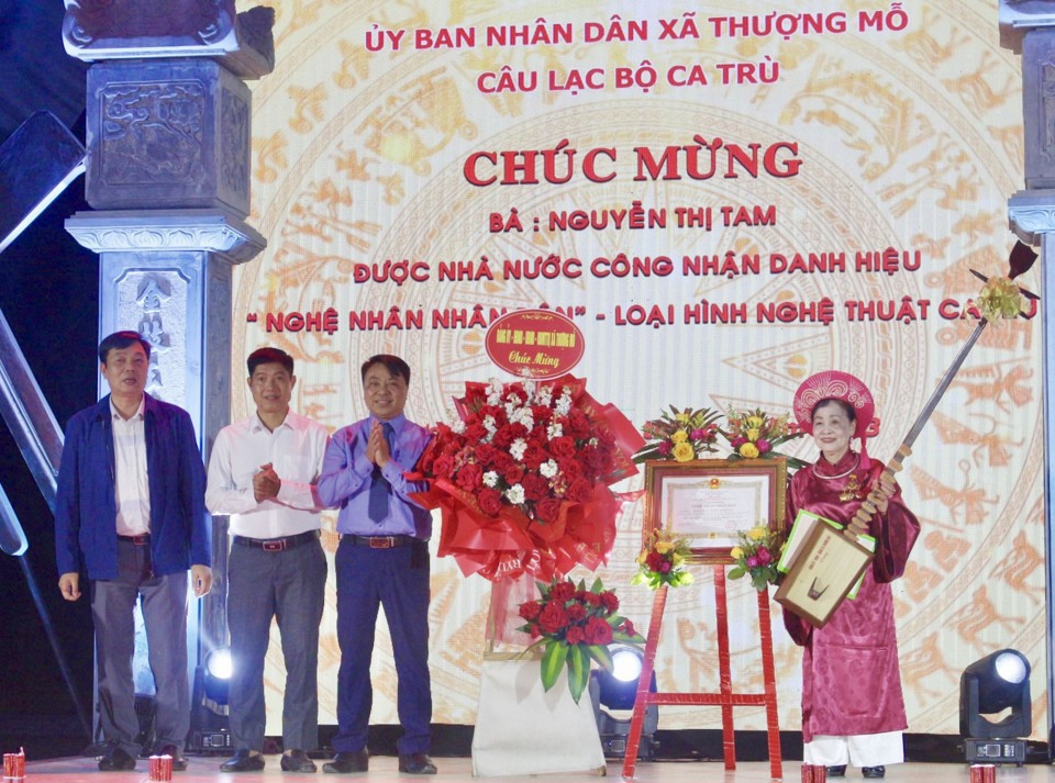 L&atilde;nh đạo x&atilde; Thượng Mỗ trao Bằng c&ocirc;ng nhận Nghệ nh&acirc;n Nh&acirc;n d&acirc;n v&agrave; tặng c&acirc;y đ&agrave;n đ&aacute;y cho nghệ nh&acirc;n Nguyễn Thị Tam.