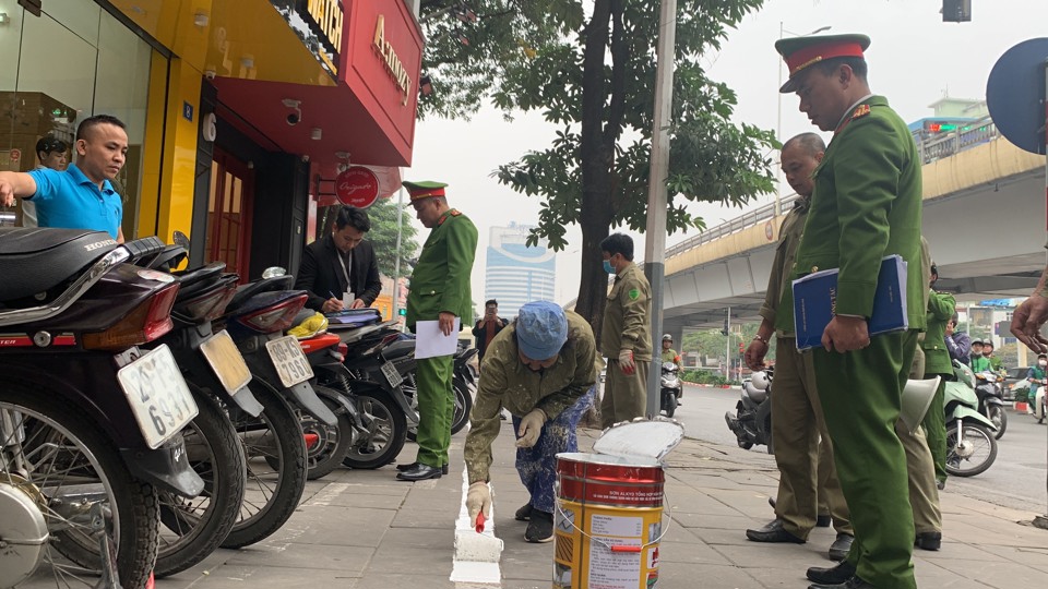 Lực lượng chức năng tổ chức sơn kẻ vạch sắp xếp phương tiện tr&ecirc;n phố Trần Duy Hưng.