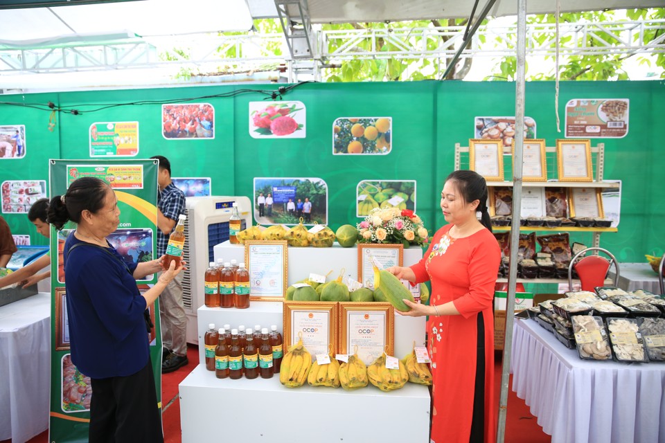 Người tiêu dùng mua sản phẩm nông sản đạt tiêu chuẩn OCOP tại hội chợ hàng Việt và sản phẩm OCOP do Sở Công Thương Hà Nội tổ chức. Ảnh: Phạm Hùng