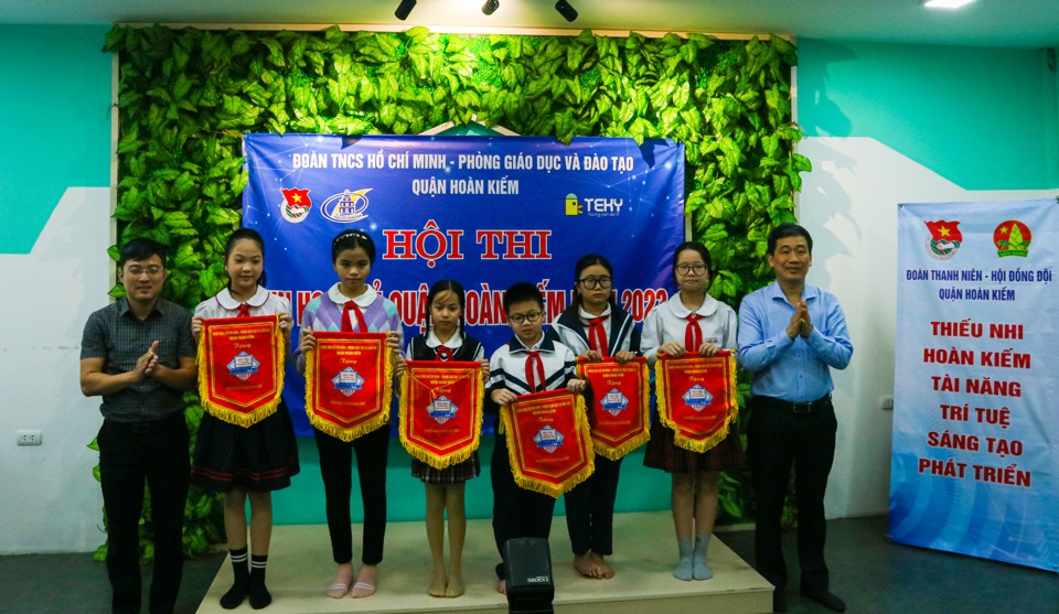 Phó Chủ tịch Thường trực Hội đồng Đội thành phố Hà Nội Bùi Mạnh Hướng và Phó Chủ tịch Ủy ban Nhân dân quận Hoàn Kiếm Nguyễn Quốc Hoàn trao cờ lưu niệm đến các học sinh dự thi.