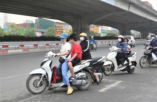 Một phụ nữ chở theo trẻ nhỏ kh&ocirc;ng đội mũ bảo hiểm đi ngược chiều tr&ecirc;n đường Nguyễn Xiển.