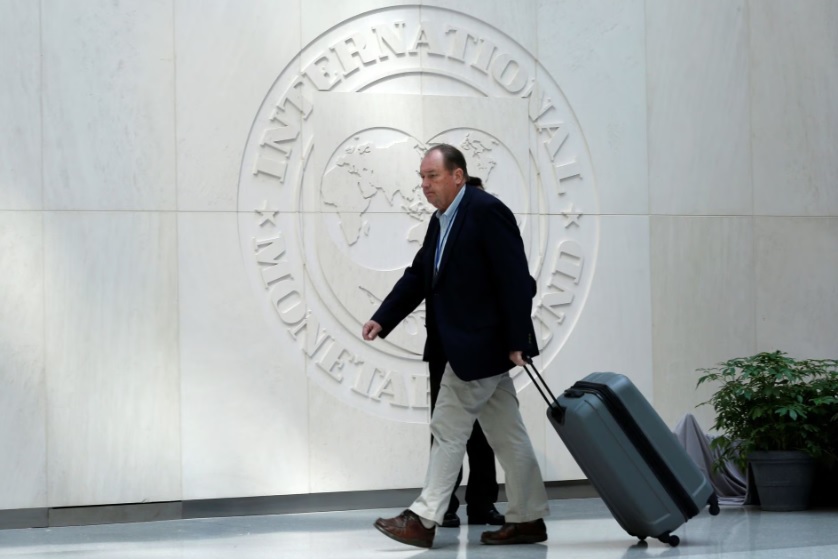 Một người đ&agrave;n &ocirc;ng đi ngang qua logo của Quỹ Tiền tệ Quốc tế trong cuộc họp m&ugrave;a xu&acirc;n của IMF/Ng&acirc;n h&agrave;ng Thế giới tại Washington, Mỹ, ng&agrave;y 21/4/2017. Ảnh: Reuters