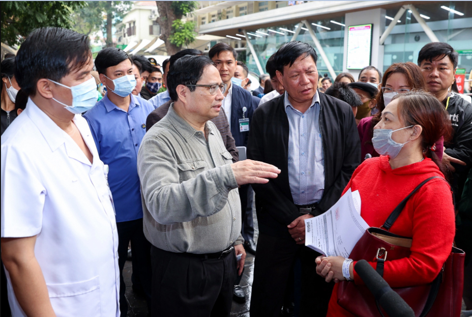 Thủ tướng thăm hỏi người nhà bệnh nhân về tình hình đáp ứng vật tư y tế và thuốc men tại bệnh viện Bạch Mai.  Ảnh: Nhật Bắc