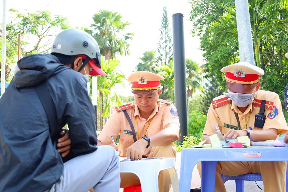 Tổ c&ocirc;ng t&aacute;c lập bi&ecirc;n bản xử phạt người điều khiển phương tiện vi phạm về an to&agrave;n giao th&ocirc;ng. Ảnh Trung Phạm