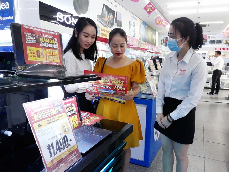 Người ti&ecirc;u d&ugrave;ng mua m&aacute;y t&iacute;nh x&aacute;ch tay giảm gi&aacute; tại si&ecirc;u thị điện m&aacute;y Media Mart. Ảnh: Ho&agrave;i Nam