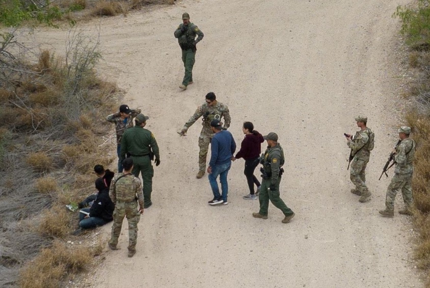 C&aacute;c nh&acirc;n vi&ecirc;n tuần tra bi&ecirc;n giới v&agrave; c&aacute;c binh sĩ Lực lượng Vệ binh Quốc gia của Qu&acirc;n đội Texas bắt giữ những người di cư đang trốn trong bụi rậm sau khi họ băng qua s&ocirc;ng Rio Grande v&agrave;o Mỹ từ Mexico ở La Joya. Ảnh: Reuters