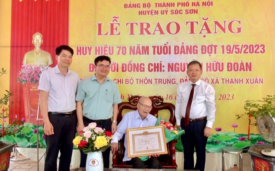 Ph&oacute; B&iacute; thư Thường trực Huyện uỷ S&oacute;c Sơn Nguyễn Nam H&agrave; (ngo&agrave;i c&ugrave;ng b&ecirc;n phải) trao Huy hiệu 70 năm tuổi Đảng cho &ocirc;ng Nguyễn Hữu Đo&agrave;n.