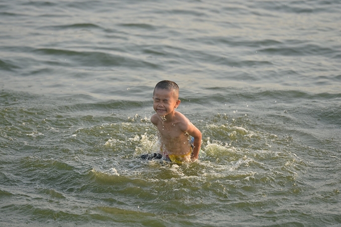 Một em b&eacute; đang tập bơi dưới sự gi&aacute;m s&aacute;t của bố