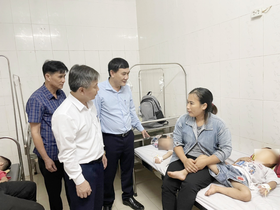 Chánh văn phòng Sở GD&ĐT và bác sĩ Phạm Ngọc Quy thăm hỏi, động viên gia đình các cháu có con bị ngộ độc thực phẩm. Ảnh Chi cục ATVSTP Nghệ An