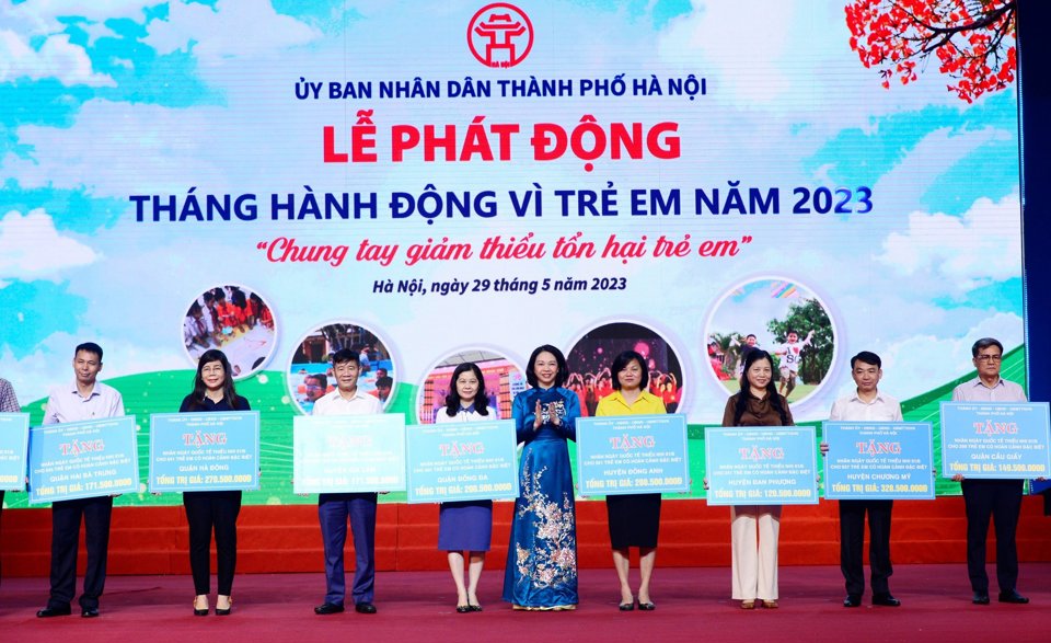 Ph&oacute; Chủ tịch UBND TP H&agrave; Nội Vũ Thu H&agrave; trao biển tượng trưng kinh ph&iacute; hỗ trợ trẻ em cho l&atilde;nh đạo c&aacute;c quận, huyện. Ảnh: Phạm H&ugrave;ng.&nbsp;