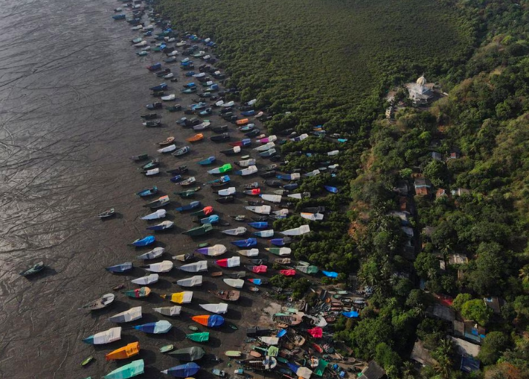 Những chiếc thuyền đ&aacute;nh c&aacute; phủ bạt đậu tr&ecirc;n bờ trước khi mưa gi&oacute; m&ugrave;a xuất hiện ở ngoại &ocirc; Mumbai, Ấn Độ, ng&agrave;y 8/6/2023. Photo: Reuters &nbsp;