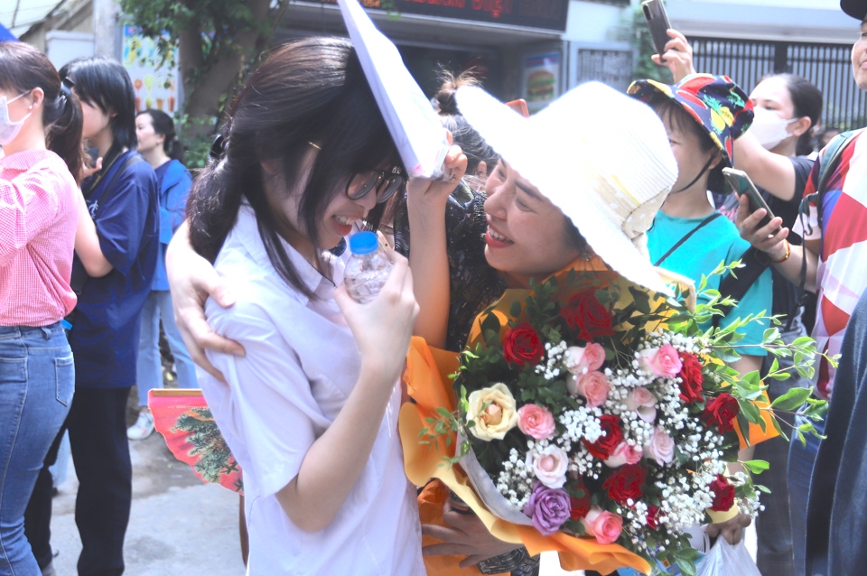 Chị Nguyễn Thị Liễu tặng hoa cho con sau khi ho&agrave;n th&agrave;nh kỳ thi. Ảnh: Lại Tấn.