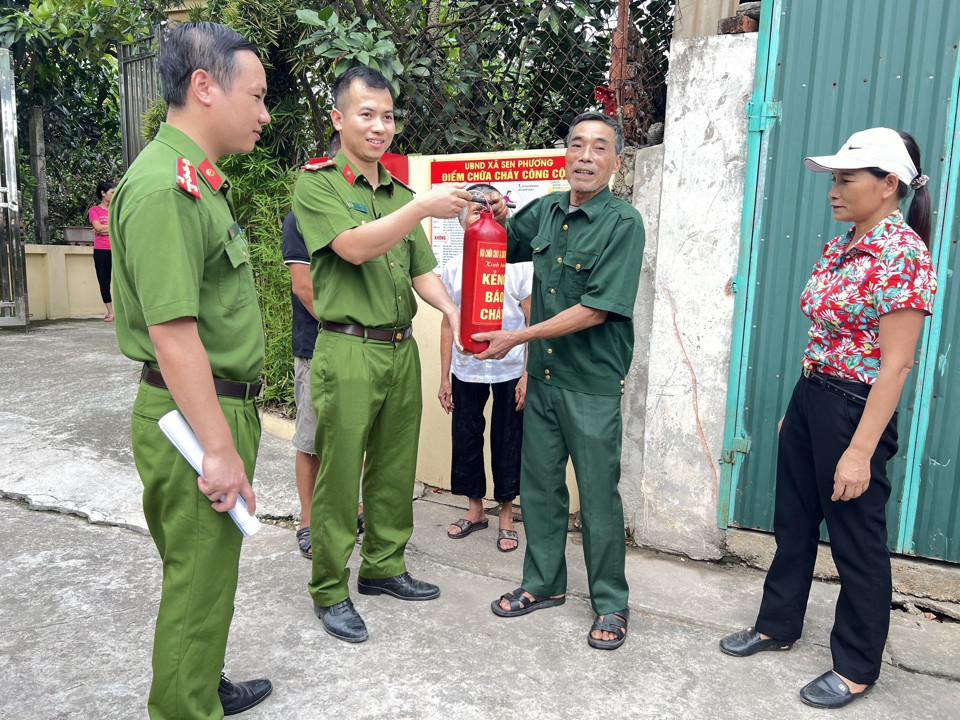 Cảnh sát phòng cháy, chữa cháy Công an TP Hà Nội trao kẻng báo cháy cho người dân. Ảnh: Bảo Trung