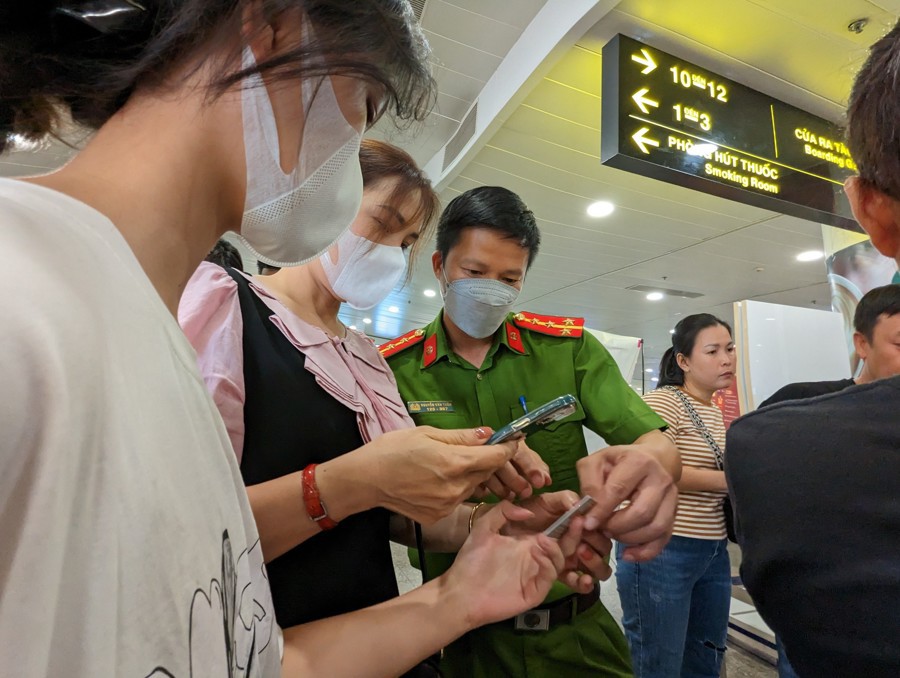 C&ocirc;ng an TP H&agrave; Nội hướng dẫn hỗ trợ người d&acirc;n k&iacute;ch hoạt định danh điện tử tại s&acirc;n bay Nội B&agrave;i. Ảnh: Ph&uacute; Kh&aacute;nh