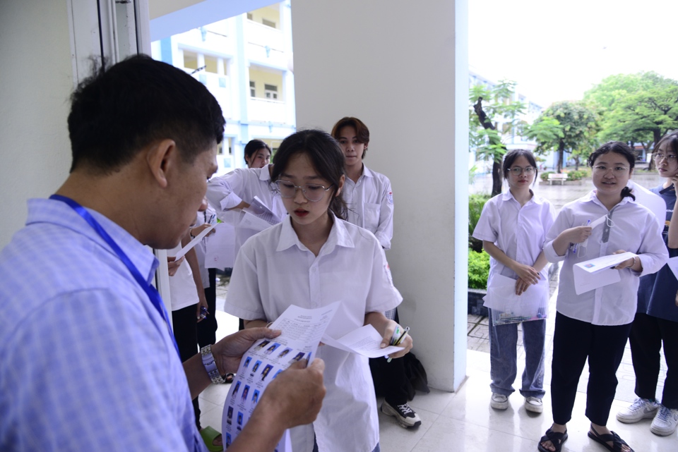 Giám thị kiểm tra thông tin thí sinh trước khi vào phòng tại điểm thi THCS Tiền Phong, huyện Mê Linh. Ảnh: Phạm Hùng
