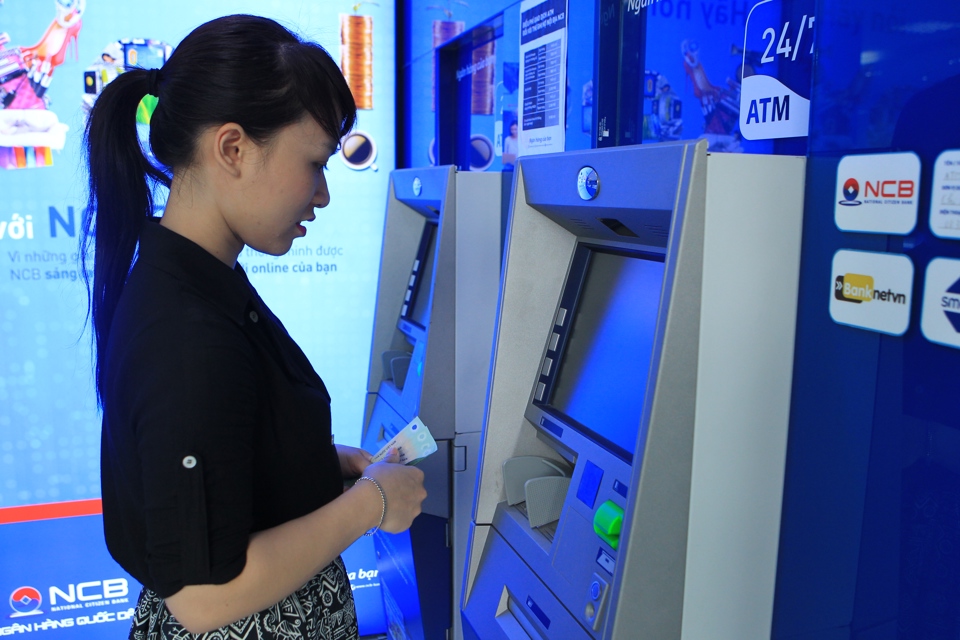 Người dân rút tiền lương tại một cây ATM trên đường Thái Hà, quận Đống Đa. Ảnh: Công Hùng