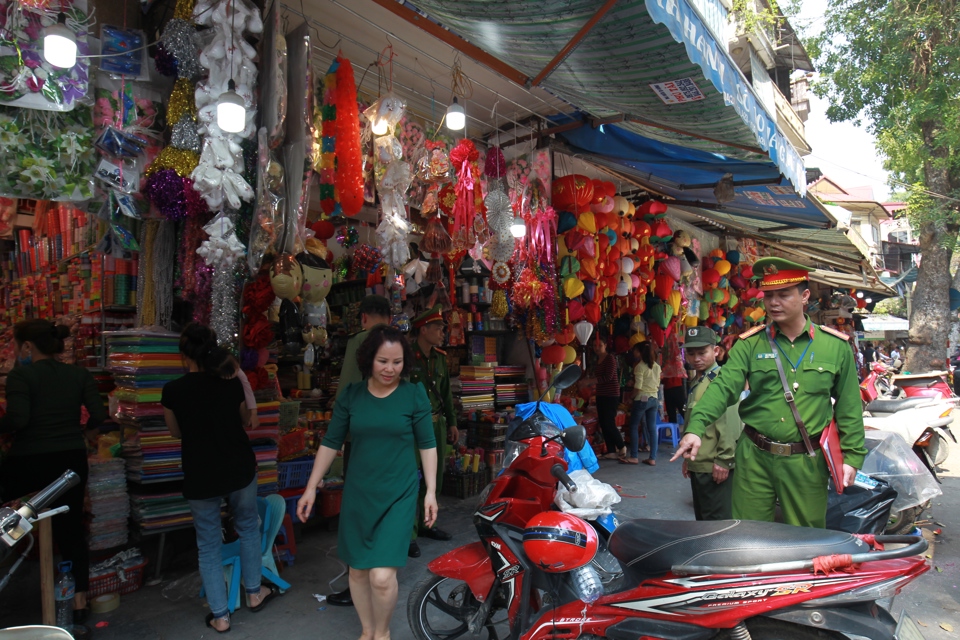 C&ocirc;ng an quận Ho&agrave;n Kiếm nhắc nhở người kinh doanh tr&ecirc;n vỉa h&egrave; phố H&agrave;ng M&atilde;. Ảnh: C&ocirc;ng H&ugrave;ng