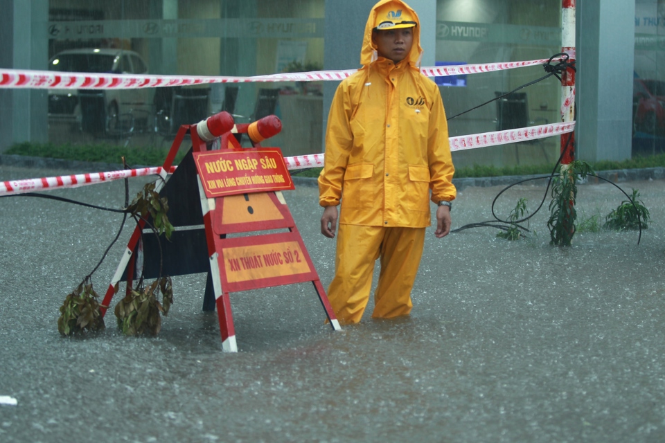 Công nhân thoát nước ứng trực tại một điểm ngập úng trên đường Phạm Hùng, Hà Nội. Ảnh: Chiến Công