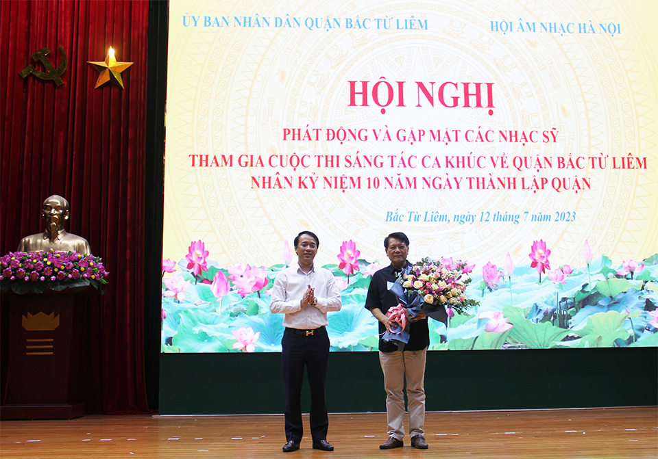 Chủ tịch UBND quận Bắc Từ Li&ecirc;m Lưu Ngọc H&agrave; tặng hoa đại di&ecirc;̣n nhạc sĩ.