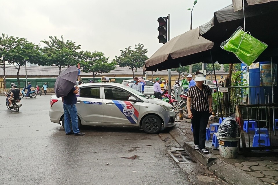 Ngay tại khu vực cổng v&agrave;o d&agrave;nh cho xe bu&yacute;t (đường Giải Ph&oacute;ng), một xe taxi ngang nhi&ecirc;n dừng, đỗ, đ&oacute;n kh&aacute;ch dưới l&ograve;ng đường.