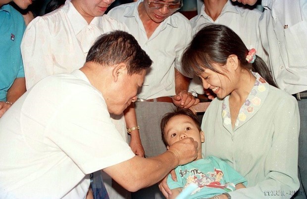 Ph&oacute; Thủ tướng Nguyễn Kh&aacute;nh cho trẻ uống vitamin A ph&ograve;ng chống bệnh kh&ocirc; mắt tại phường L&aacute;ng Hạ, H&agrave; Nội (1994). (Ảnh: Thu Ho&agrave;i/TTXVN)