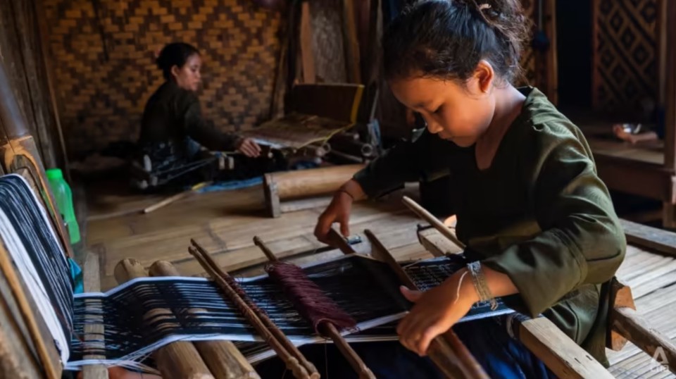 Một người phụ nữ Baduy v&agrave; con g&aacute;i dệt vải thủ c&ocirc;ng tại nh&agrave; của họ ở l&agrave;ng Kanekes, Indonesia. Ảnh: CNA