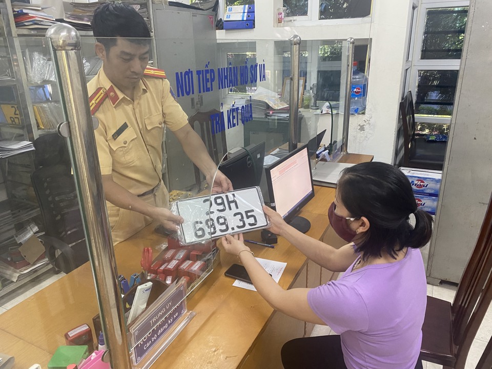 Người dân làm thủ tục đăng ký biển số xe tại Đội CSGT, Công an huyện Mê Linh chiều 25/7. Ảnh: Phạm Hùng