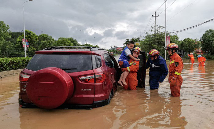 Lực lượng cứu hộ giải cứu trẻ nhỏ khỏi xe cộ ngập nước ở Tuyền Ch&acirc;u. Ảnh: AFP