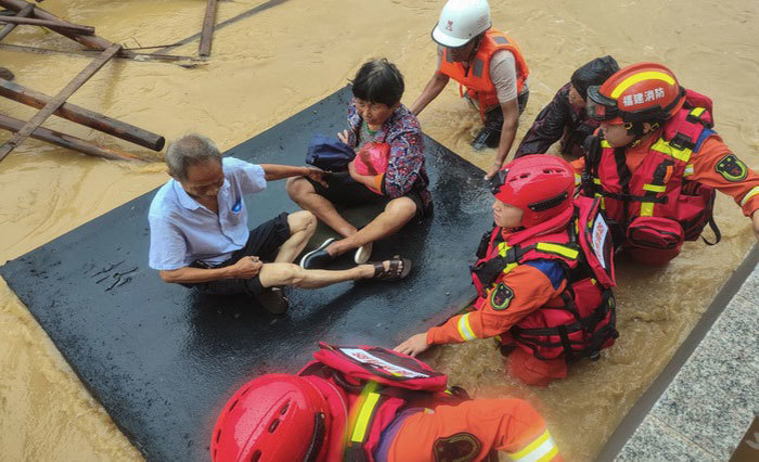 Lực lượng cứu hộ giải cứu người d&acirc;n khỏi v&ugrave;ng ngập lũ ở Tuyền Ch&acirc;u h&ocirc;m 28/7. Ảnh: AFP