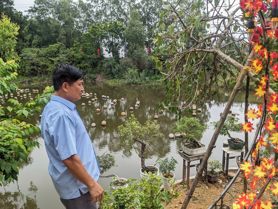 &Ocirc;ng Kh&aacute;nh b&ecirc;n cạnh hồ nu&ocirc;i trai lấy ngọc. Ảnh: Qu&yacute; Nguyễn