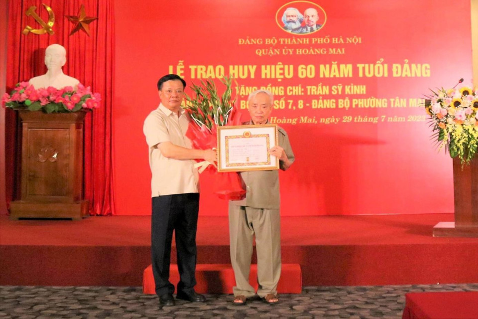 Bí thư Thành ủy Hà Nội Đinh Tiến Dũng trao Huy hiệu 60 năm tuổi Đảng tặng đảng viên Trần Sỹ Kình. Ảnh: Hiền Thu