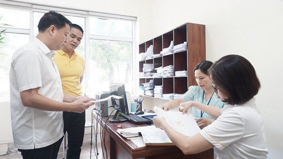 Chi cục trưởng Chi cục ATVSTP Hà Nội Đặng Thanh Phong kiểm tra việc triển khai thực hiện bưu chính công ích tại Bộ phận một cửa. Ảnh: Trần Thảo