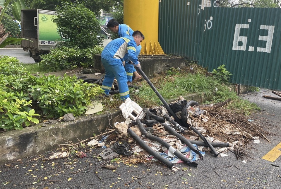 C&ocirc;ng nh&acirc;n m&ocirc;i trường dọn dẹp r&aacute;c thải bị tập kết sai quy định tại đường đi bộ dọc đường L&aacute;ng.